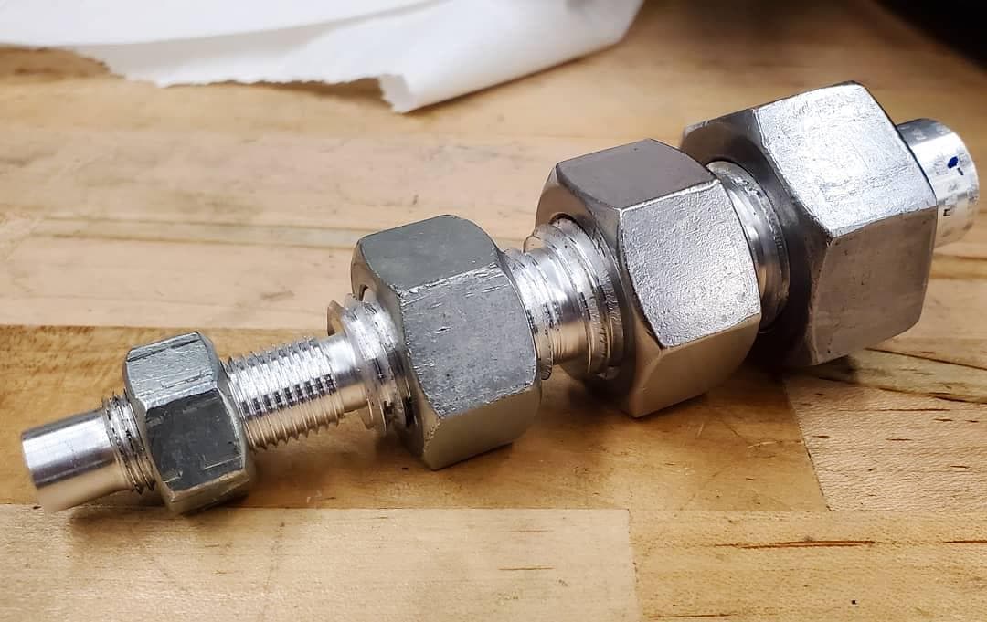 Threaded shaft with nuts demonstrating single-point thread cutting